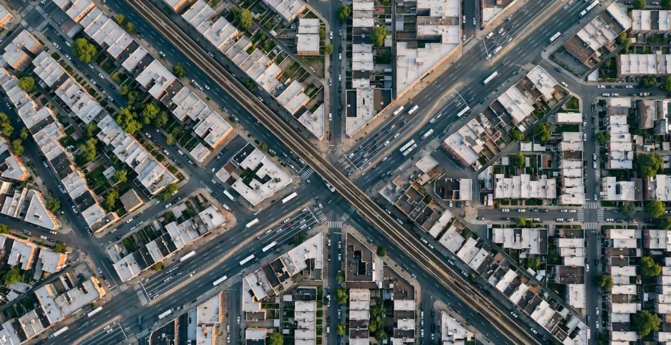 Vue aérienne minimaliste d'un quartier urbain avec zones calmes mises en évidence par rapport aux axes bruyants