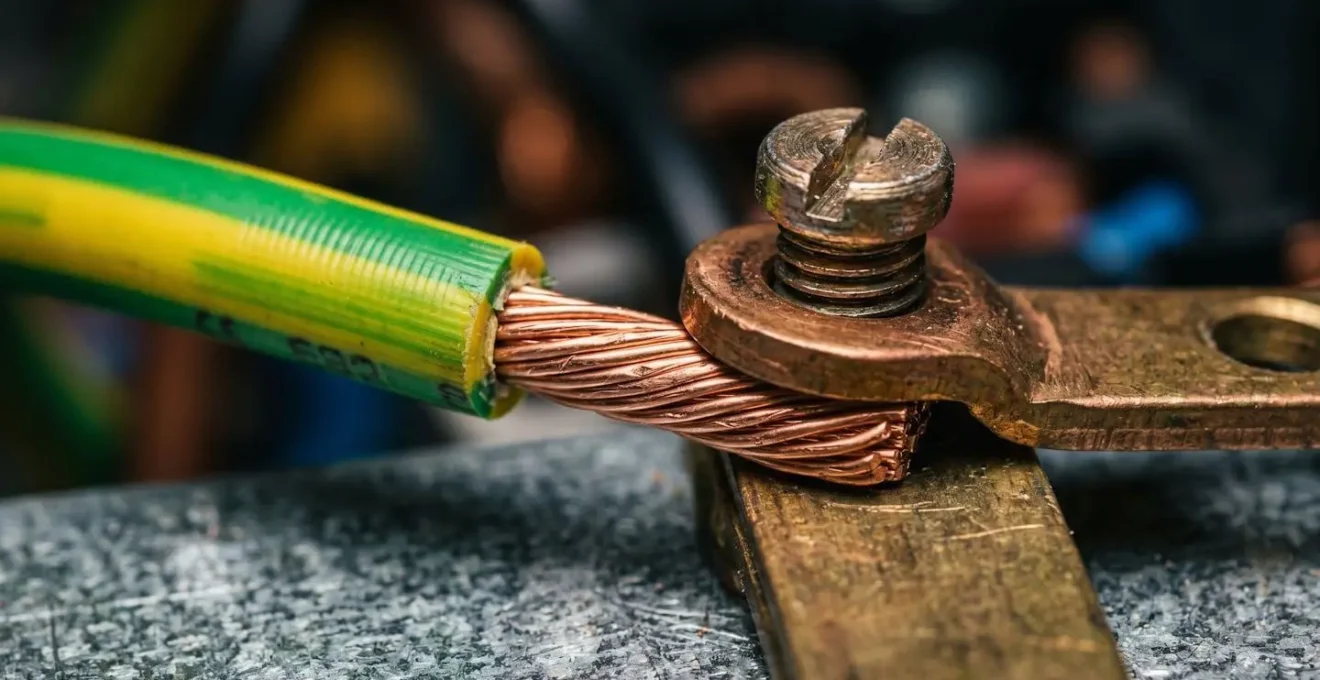 Gros plan macro sur une connexion de terre avec fil vert-jaune, texture et détails techniques visibles